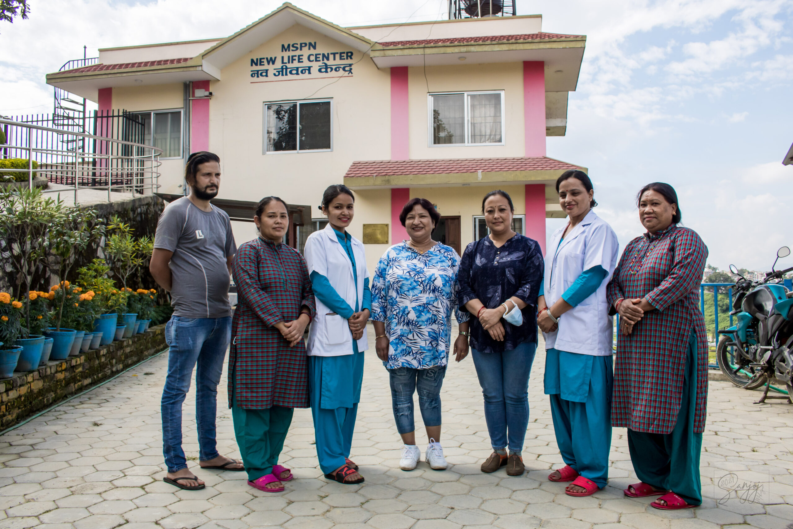 Staff at the New Life Center pose for a photo in front of the the building.