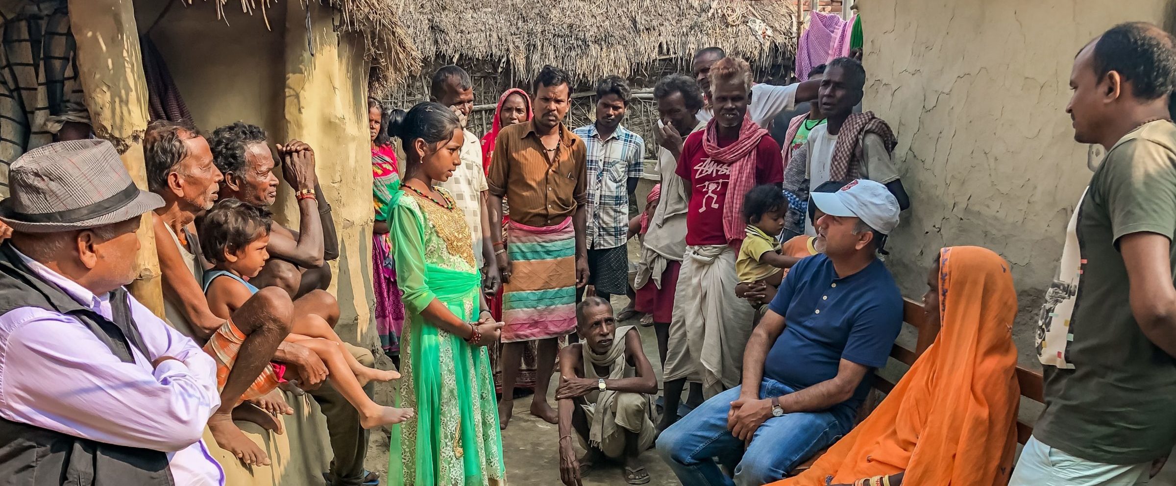 A group of Musahar Dalit villagers look on as a teenage girl speaks to NYF President Som Paneru