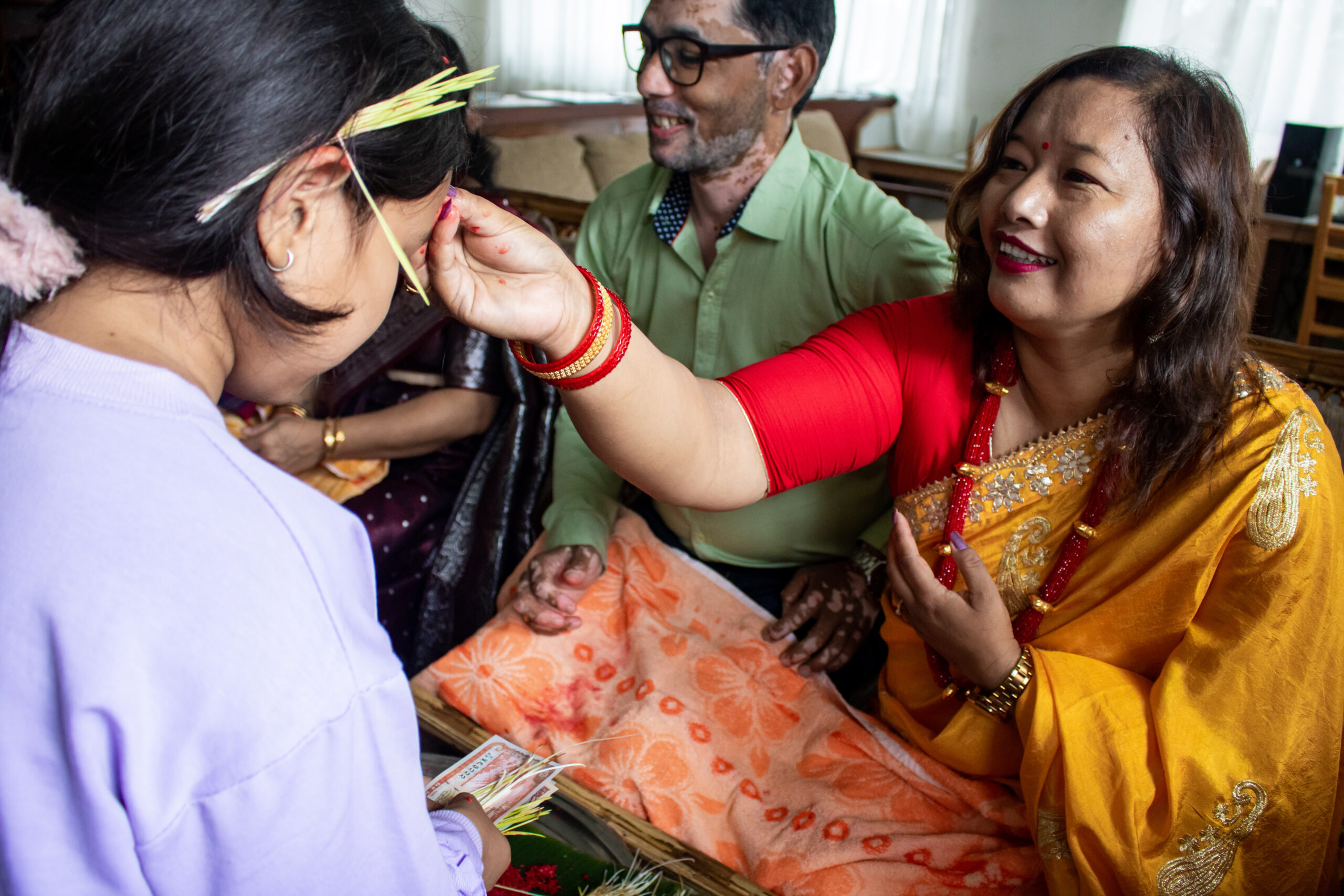 Samana-Aunty, a house parent at Olgapuri Children's Village, gives a junior girl a tika blessing.